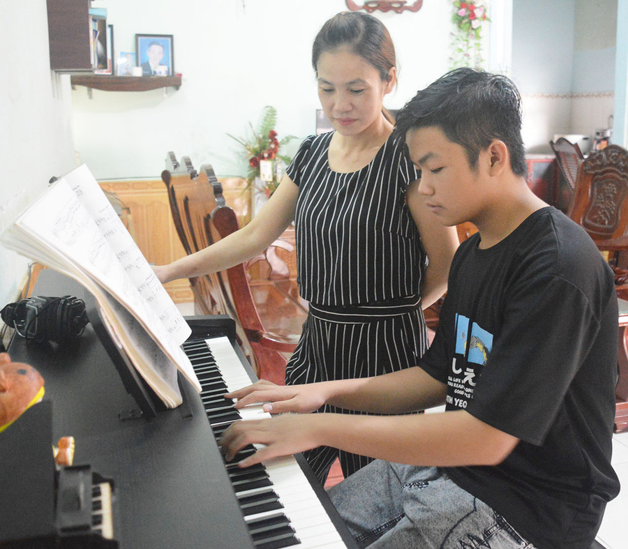 Em Trần Tuấn Kiệt say sưa bên phím đàn. Ảnh: P.D Em Trần Tuấn Kiệt say sưa bên phím đàn. Ảnh: P.D