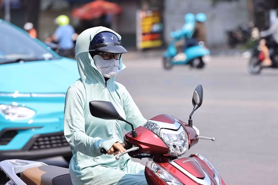 Người dân trang bị chống nắng khi ra đường. (Ảnh: Minh Đức/TTXVN)