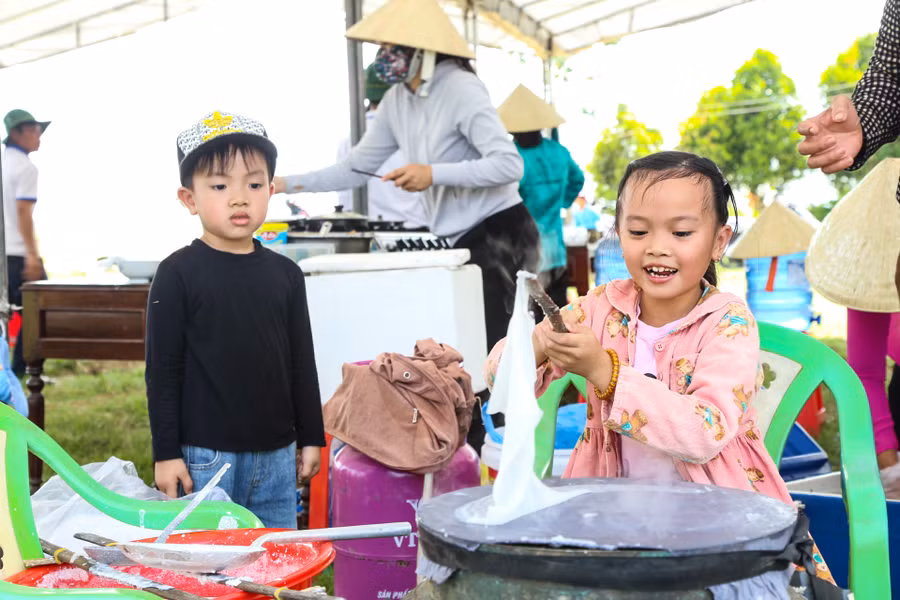 Tham gia lễ hội ngày mùa, các học sinh, người dân và du khách còn được trải nghiệm làm các loại bánh truyền thống của người dân địa phương như: Bánh ướt, bánh xèo, bánh bèo. Tất cả các loại bánh này đều có nguyên liệu chính là từ cây lúa của quê hương Đức Tân. Ảnh: Hải Phong