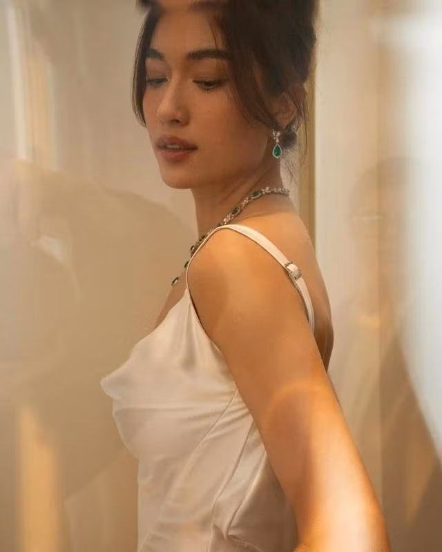 Kiểu đầm này là điểm nhấn vô cùng quyến rũ và nổi bật với việc trang trí hoa lụa tinh tế, được khâu tay cẩn thận, tạo ra một vẻ đẹp mềm mại và lãng mạn cho trang phục. Cùng với đó, việc thiết kế chia phần trước tạo điểm nhấn thú vị hơn bao giờ hết.