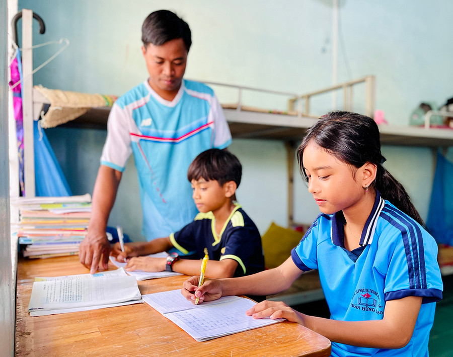 Em Ksor Nga (áo xanh) rất thích ở lại trường vì được các thầy-cô giáo chăm sóc từ việc sinh hoạt tới học tập. Ảnh: Mai Ka