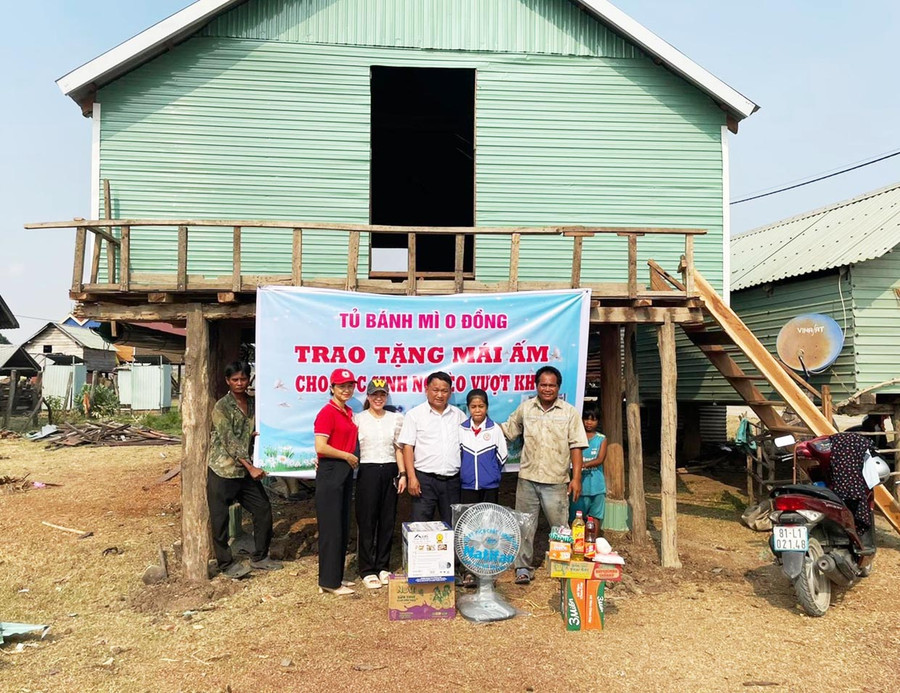 Thầy Vũ Văn Tùng (ở giữa) bàn giao nhà cho em Nay H&apos;Lại và gia đình. Ảnh: V.C