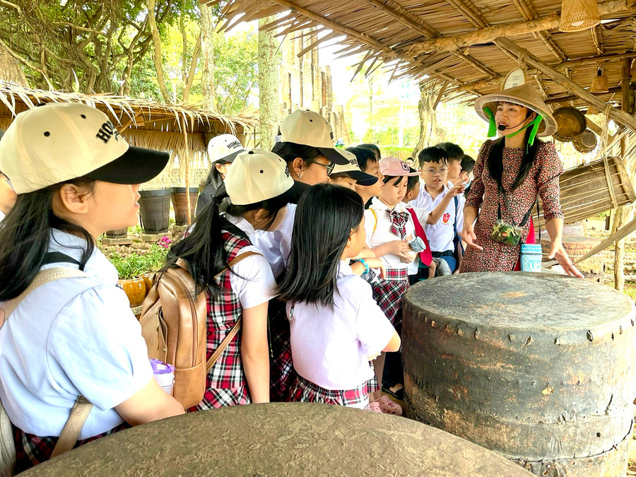 Các em học sinh hào hứng nghe thuyết minh về các hiện vật quý tại &quot;bảo tàng mở&quot; Thiên đường Tây Nguyên (Quảng trường Đại Đoàn Kết, TP. Pleiku). Ảnh: Lam Nguyên