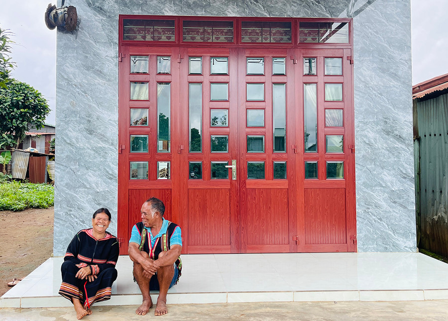 Vợ chồng bà Puih Bil trước căn nhà mới khang trang do Mạnh Thường Quân hỗ trợ xây dựng. Ảnh: M.K