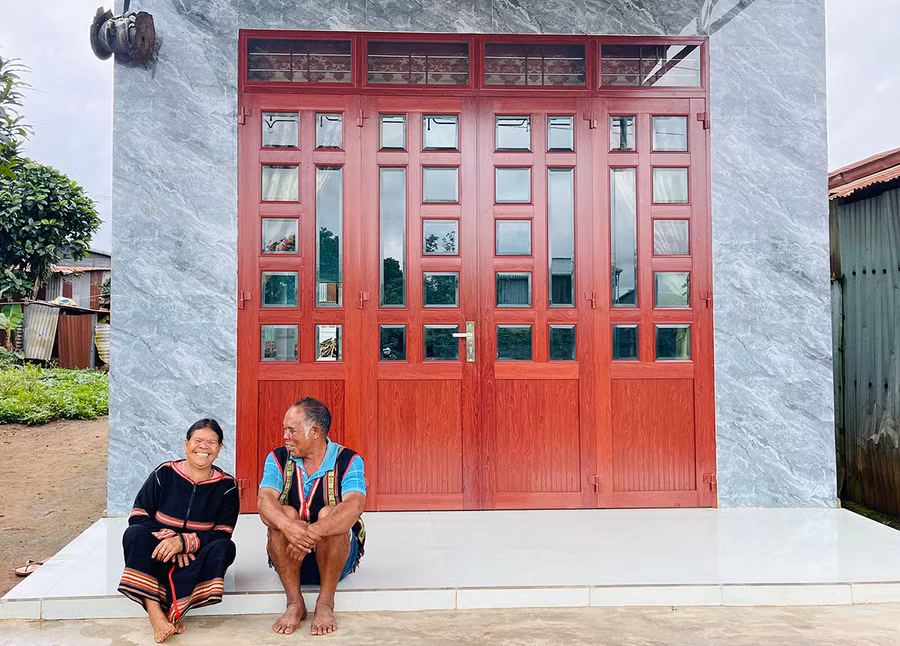 Vợ chồng bà Puih Bil trước căn nhà mới khang trang do Mạnh Thường Quân hỗ trợ xây dựng. Ảnh: M.K