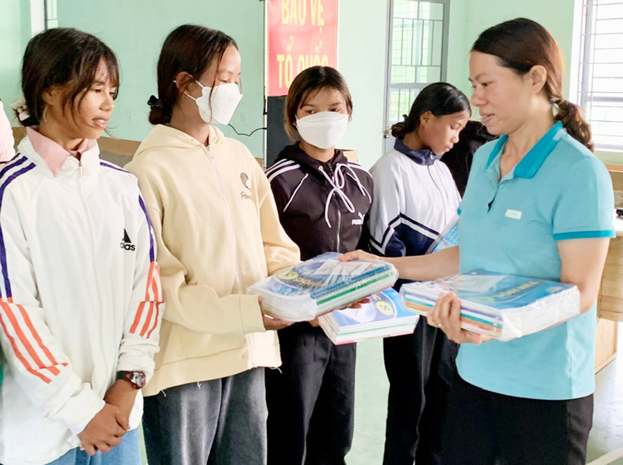 Giáo viên Trường Phổ thông Dân tộc bán trú Tiểu học và THCS Nguyễn Khuyến (xã Chư Krêy, huyện Kông Chro) tặng sách giáo khoa mới của Mạnh Thường Quân cho các em học sinh. Ảnh: N.N