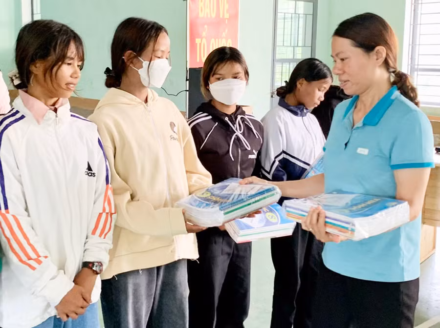 Giáo viên Trường Phổ thông Dân tộc bán trú Tiểu học và THCS Nguyễn Khuyến (xã Chư Krêy, huyện Kông Chro) tặng sách giáo khoa mới của Mạnh Thường Quân cho các em học sinh. Ảnh: N.N