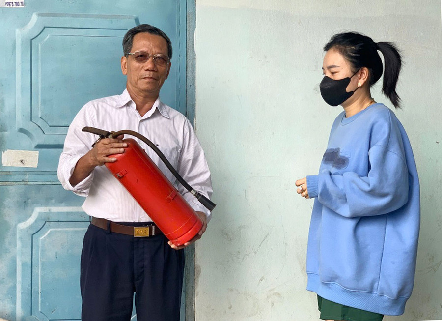 Ông Trần Ngọc Lợi-Bí thư Chi bộ kiêm Tổ trưởng tổ dân phố 9 (phường Ia Kring) hướng dẫn người dân sử dụng bình chữa cháy xách tay. Ảnh: R.H