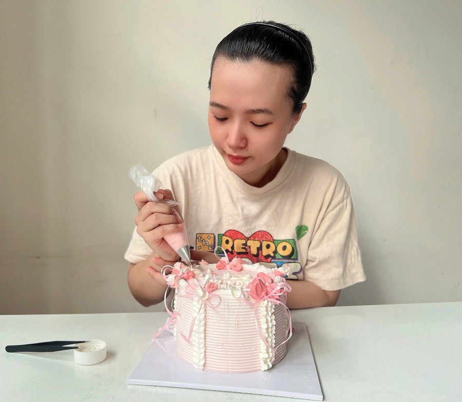 Chị Hoài Thương đang trang trí bánh kem . Ảnh: PHƯƠNG VY
