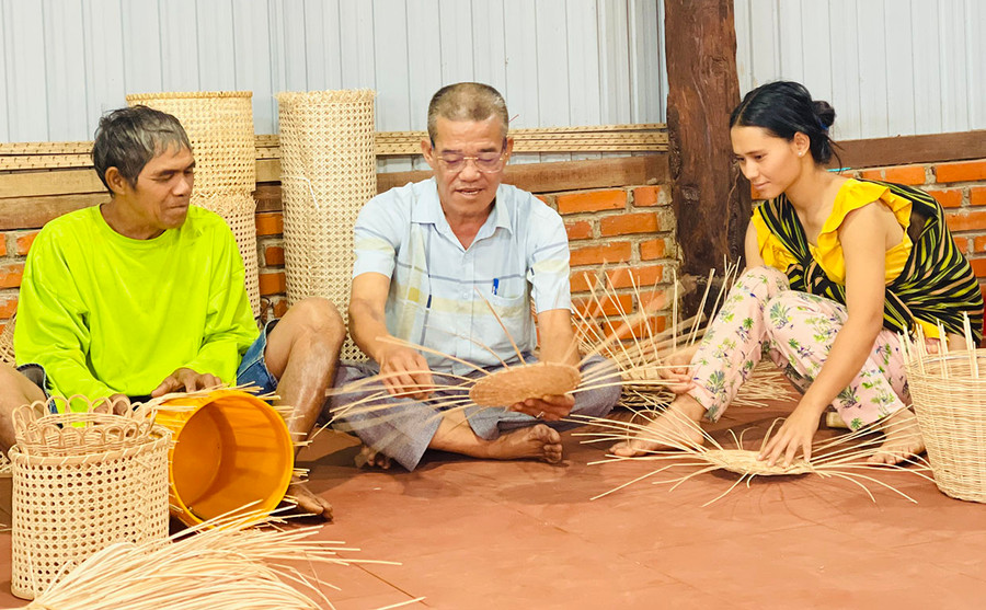 Ông Nguyễn Xuân Quang (ngồi giữa) dạy kỹ thuật đan lát cho bà con Jrai. Ảnh: T.D