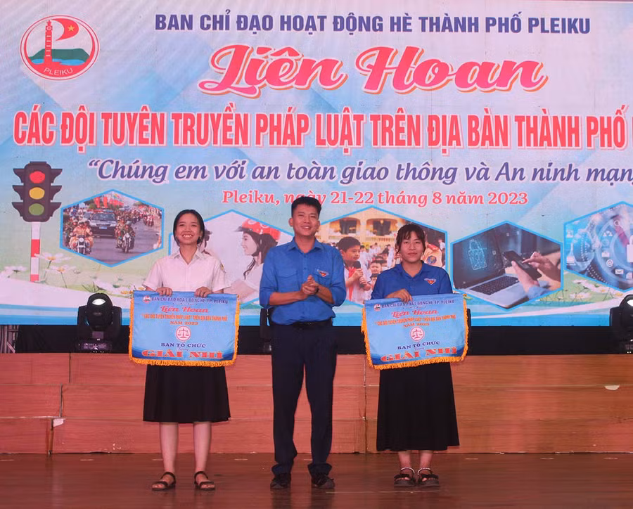 Anh Thái Giang Nam (ở giữa)-Bí thư Thành Đoàn Pleiku trao giải nhì cho các đội thi. Ảnh: Minh Nhật