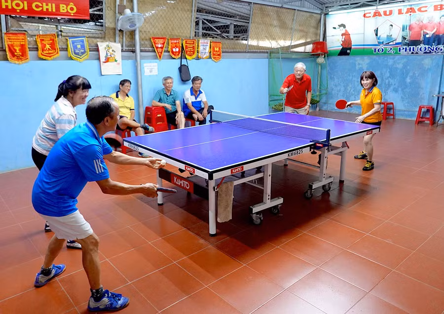 Các thành viên CLB Bóng bàn tổ dân phố 2 (phường Hoa Lư) tập luyện tại hội trường tổ dân phố. Ảnh: H.T