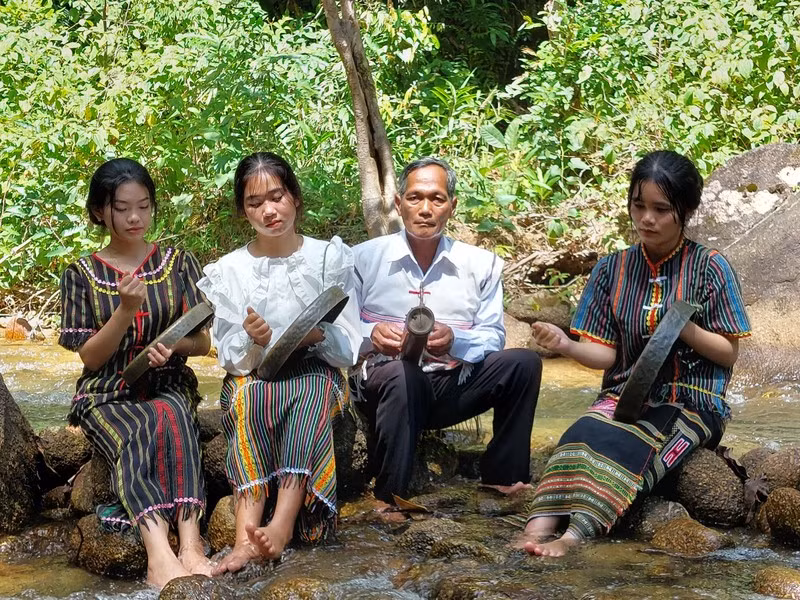 Nghệ nhân K’Trời dạy các cháu học sinh chơi cồng chiêng.