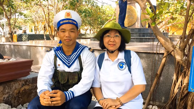 Lính trẻ Hoàng Văn Trình chụp ảnh lưu niệm với đại biểu ra thăm đảo. Ảnh: V.T