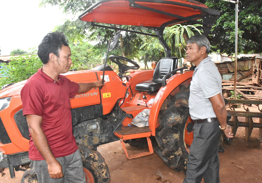 Anh Siu Lê (bìa trái) cùng ông Lê Cường-Chủ tịch Hội Cựu chiến binh xã Ia Blư bên chiếc máy cày làm đất của mình. Ảnh: Đinh Yến