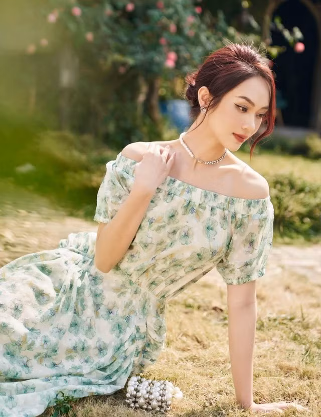 Mẫu váy này mang đậm phong cách bánh bèo nữ tính với thiết kế trễ vai điểm hoa màu xanh lá. Nó không chỉ giúp tôn lên ngoại hình quyến rũ e ấp mà còn khiến vẻ đẹp hình thể của nàng được phô diễn trọn vẹn.