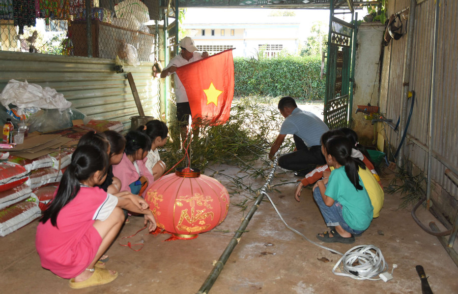 Những đứa trẻ quanh xóm tập trung xem người lớn làm nêu. Ảnh: HT