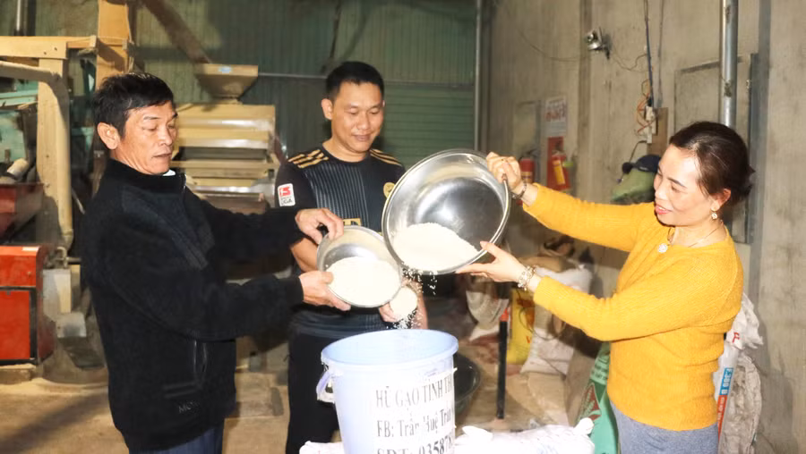 Chị Trần Thị Huệ cùng người dân ủng hộ “Hũ gạo tình thương”. Ảnh: Ngọc Minh