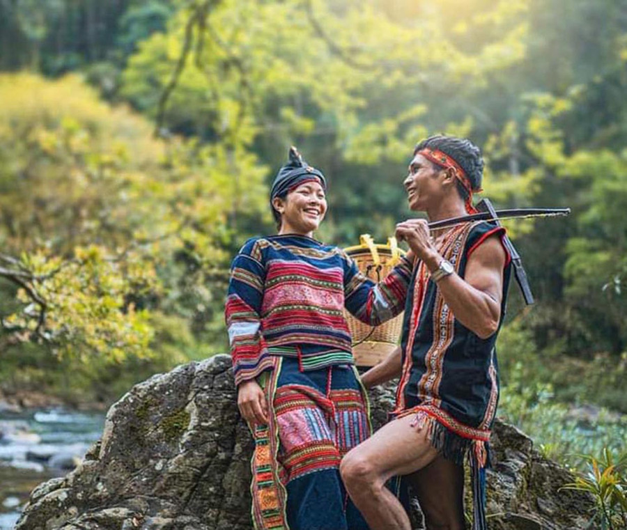 Trưởng thôn Đinh Văn Quý cùng phụ nữ Bahnar trong trang phục truyền thống. Ảnh: NVCC