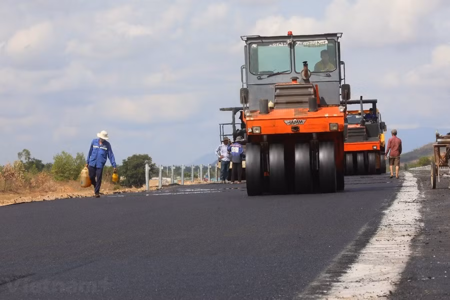 Nhà thầu thi công thảm bê tông nhựa mặt đường Dự án Cao tốc Bắc-Nam phía Đông. (Ảnh: Việt Hùng/Vietnam+)