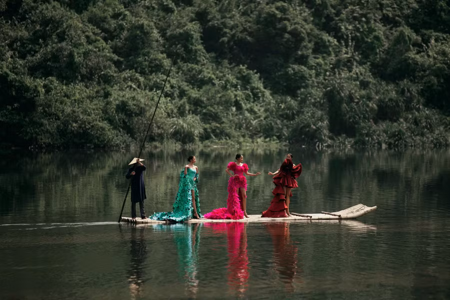 Ba hoa hậu Việt Nam mở màn trong vai trò first-face. Thay vì bước ra sàn catwalk từ phía sau sân khấu như thường lệ, ba người đẹp xuất hiện trên chiếc bè trúc, chậm rãi tiến về sàn diễn giữa âm nhạc du dương. Các nàng hậu thể hiện khả năng catwalk chuyên nghiệp cùng trang phục dạ hội có thiết kế tà dài và phom dáng dựng 3D công phu. ẢNH: KIẾNG CẬN TEAM