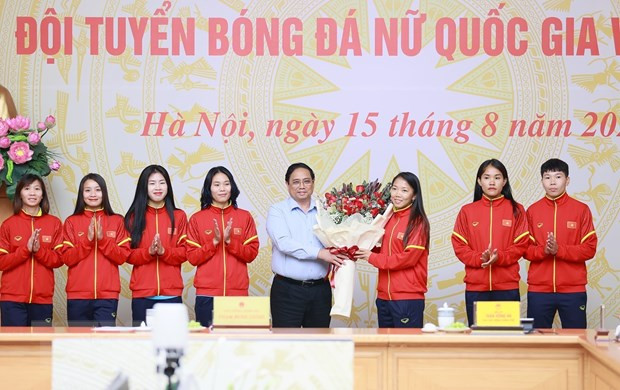 Thủ tướng Phạm Minh Chính tặng hoa cho các cầu thủ Đội tuyển Bóng đá Nữ Quốc gia Việt Nam. (Ảnh: Dương Giang/TTXVN)