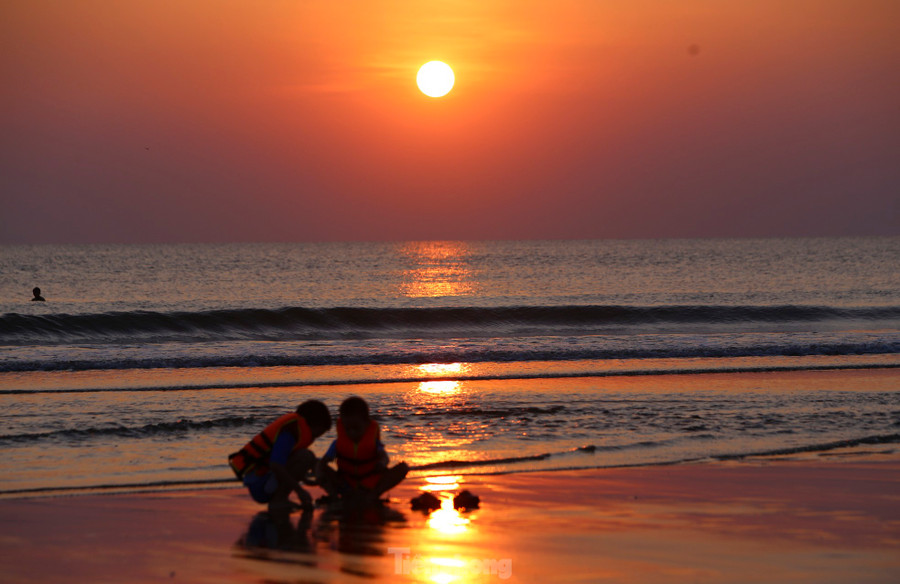 Rạng đông, những tia nắng đầu tiên hắt lên nền trời tạo nên khung cảnh ấn tượng của bãi biển.