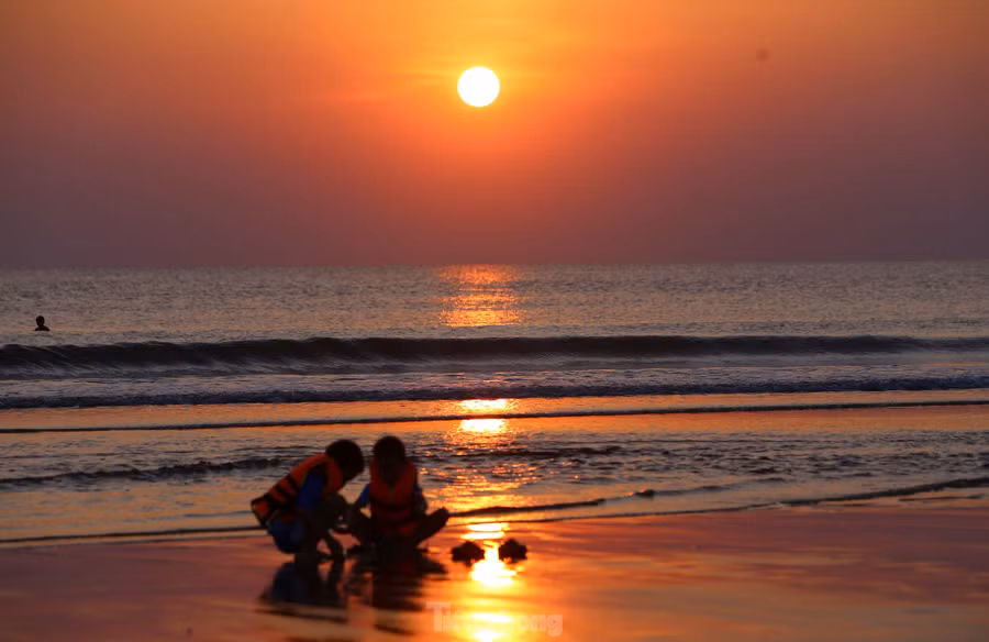 Rạng đông, những tia nắng đầu tiên hắt lên nền trời tạo nên khung cảnh ấn tượng của bãi biển.