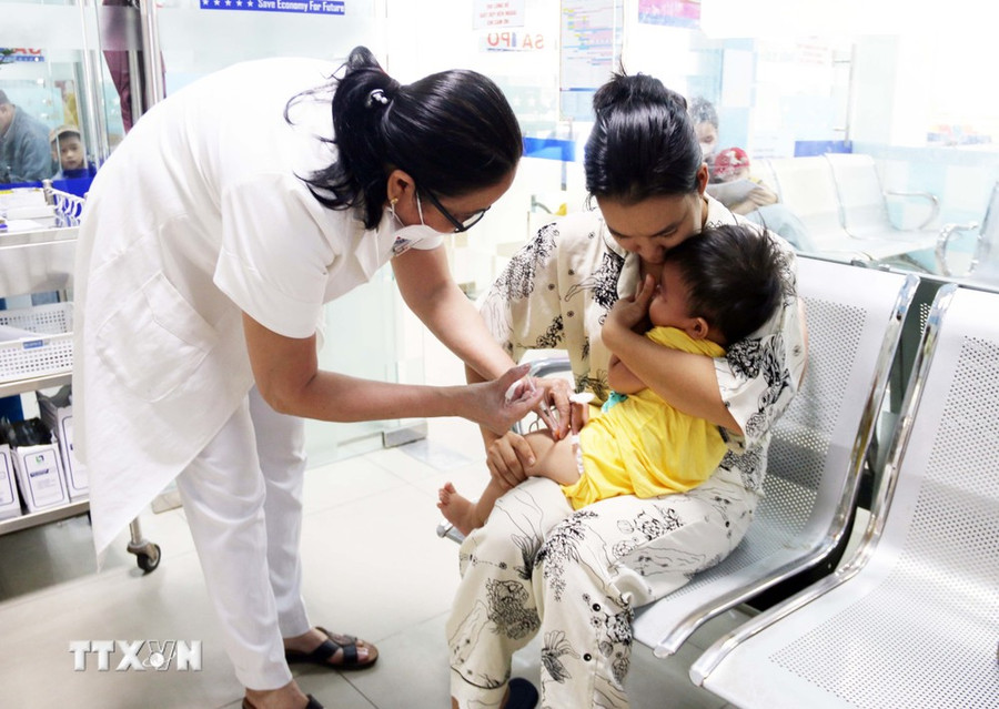 Nhân viên y tế tiêm vaccine phòng bệnh cho trẻ. (Ảnh: TTXVN/Vietnam+) Nhân viên y tế tiêm vaccine phòng bệnh cho trẻ. (Ảnh: TTXVN/Vietnam+)