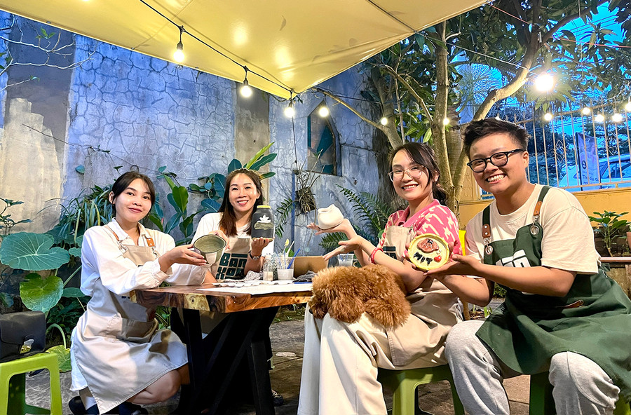 Bạn trẻ Nguyễn Ngọc Như Quỳnh-chủ tiệm gốm Bàn Xoay (bìa phải) và khách trải nghiệm bên những sản phẩm vừa hoàn thiện. Ảnh: Lam Nguyên Bạn trẻ Nguyễn Ngọc Như Quỳnh-chủ tiệm gốm Bàn Xoay (bìa phải) và khách trải nghiệm bên những sản phẩm vừa hoàn thiện. Ảnh: Lam Nguyên