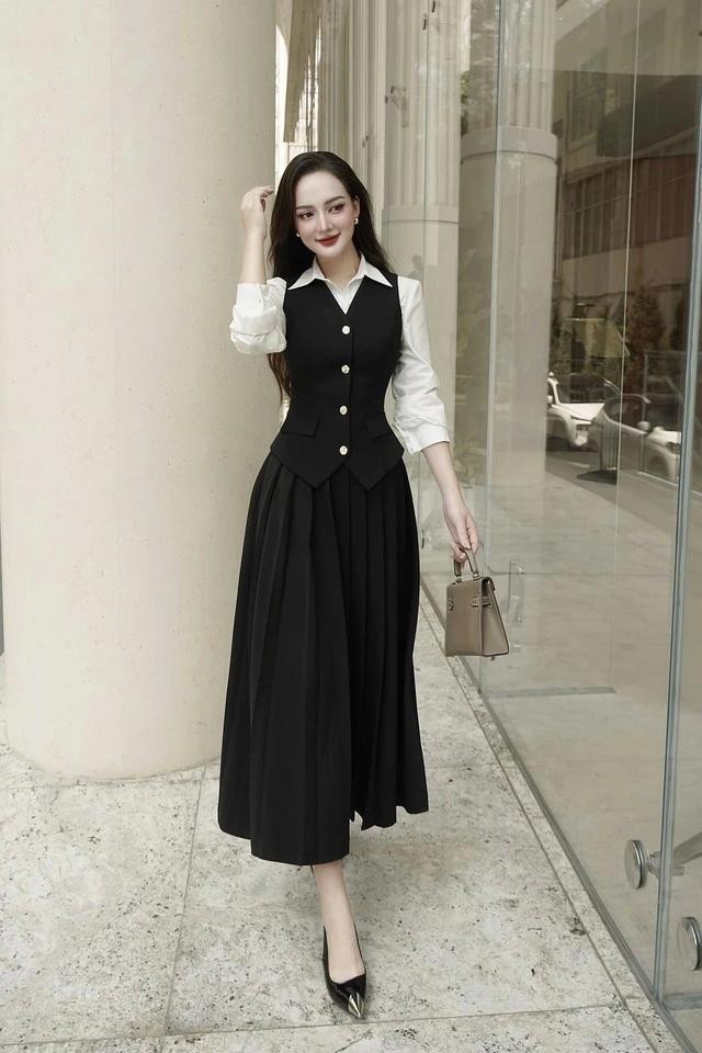 Trong trang phục tinh giản với tông màu đen huyền bí, quý cô như thu hút mọi ánh nhìn. Thiết kế áo gile cổ điển ôm nhẹ vào cơ thể kết hợp cùng chân váy dáng xòe chữ A tạo nên một tổng thể đồng hồ cát, phù hợp với nhiều dáng người. Khi được phối cùng áo sơ mi trắng càng làm tăng tính ứng dụng cho set đồ. Ảnh 2FLEURS