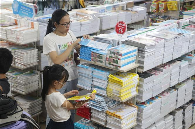 Phụ huynh và học sinh lựa chọn sách, đồ dùng học tập cho năm học mới. Ảnh: Bích Huệ/TTXVN Phụ huynh và học sinh lựa chọn sách, đồ dùng học tập cho năm học mới. Ảnh: Bích Huệ/TTXVN