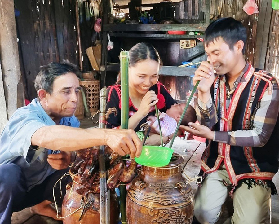 Thầy cúng mời rượu mừng cha mẹ và đứa bé đã được làm lễ cúng rụng rốn và đặt tên. Ảnh: A.D