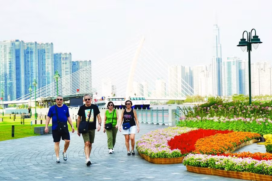 Du khách quốc tế đi dạo trên bến Bạch Đằng (quận 1, TPHCM) chiều 23-1. Ảnh: HOÀNG HÙNG