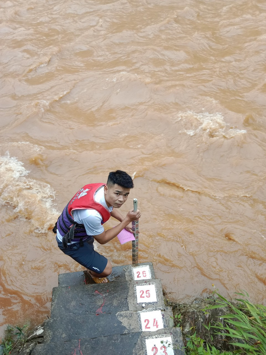 Cán bộ thủy văn đo mức nước lũ trên sông. Ảnh: HOÀI LINH Cán bộ thủy văn đo mức nước lũ trên sông. Ảnh: HOÀI LINH