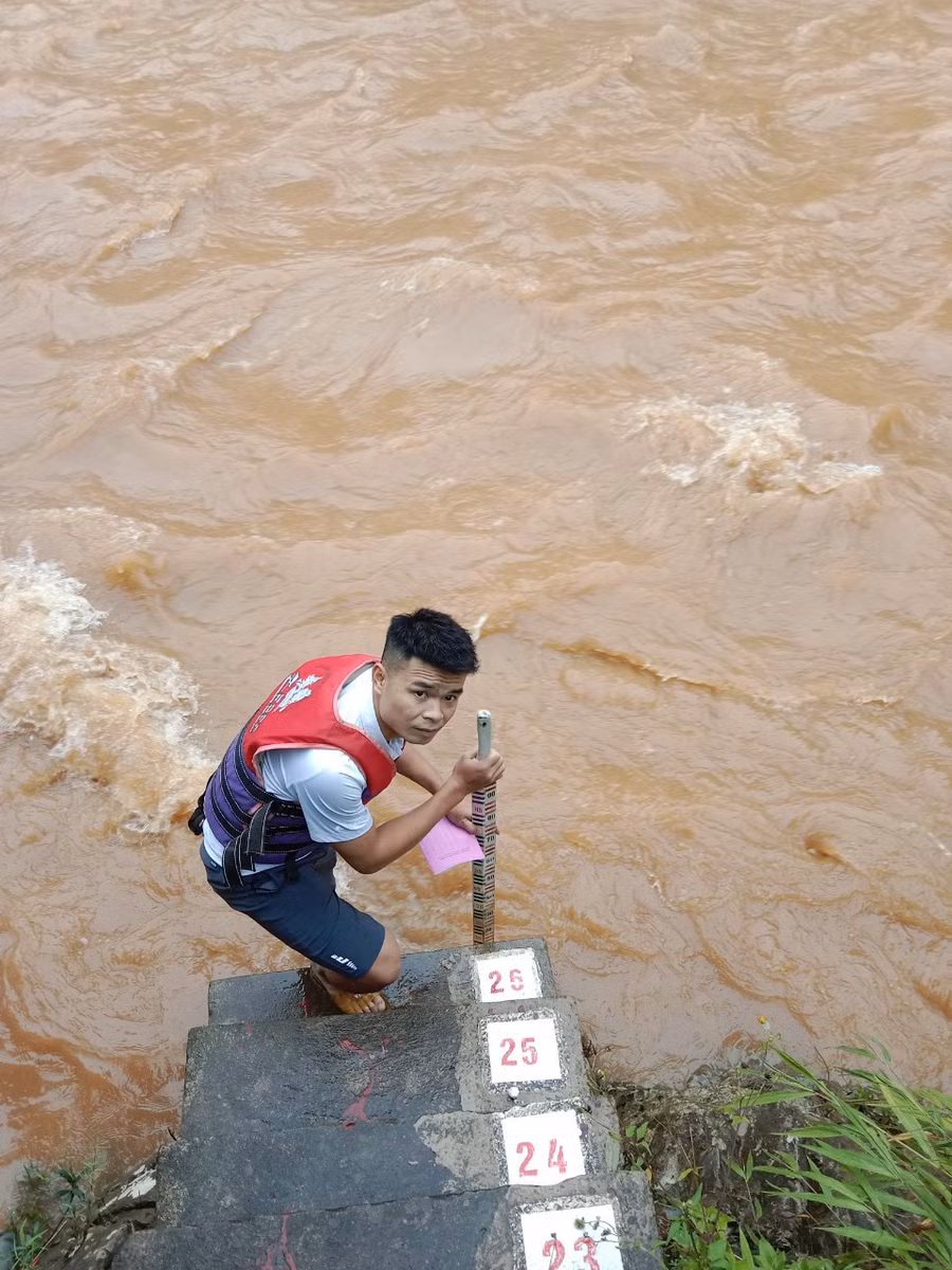 Cán bộ thủy văn đo mức nước lũ trên sông. Ảnh: HOÀI LINH