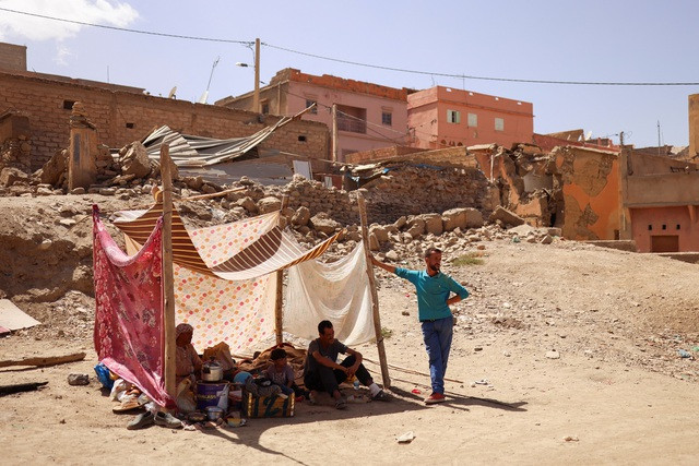 Người dân nhìn những tòa nhà bị hư hại sau trận động đất chết người ở Amizmiz (Ma Rốc). Ảnh: Reuters