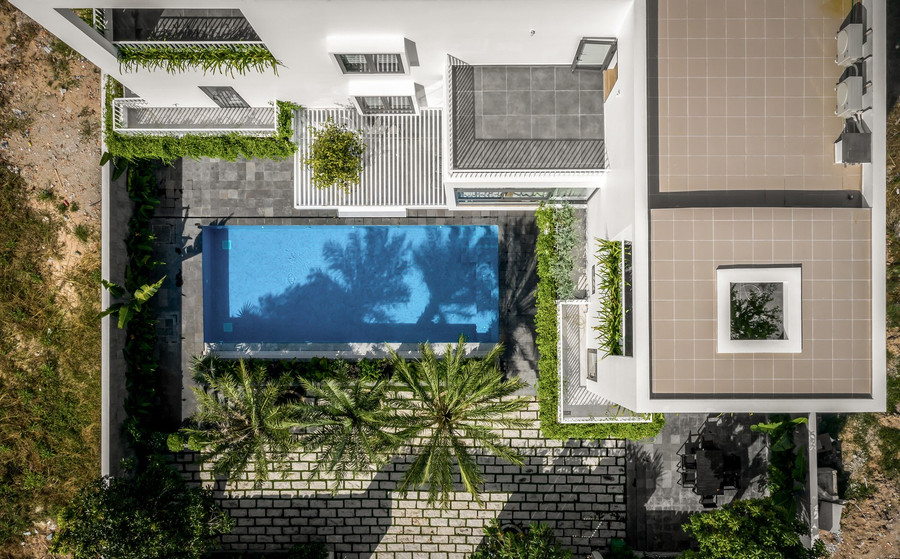 Khối nhà được thiết kế lùi nhiều so với mặt đường và phát triển theo hình chữ L ôm lấy bể bơi giúp không gian các phòng đều có hướng nhìn ra bể bơi. Khối nhà được thiết kế lùi nhiều so với mặt đường và phát triển theo hình chữ L ôm lấy bể bơi giúp không gian các phòng đều có hướng nhìn ra bể bơi.