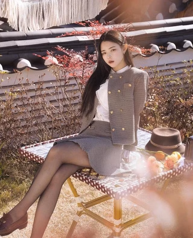Mang trong mình màu sắc hoài niệm và chứa đựng hơi hướng cổ điển pha chút hiện đại, bộ đồ này đã tái hiện thành công hình ảnh duyên dáng của người phụ nữ Á Đông. Vừa đem lại cảm giác ấm áp, vừa sang trọng trong thiết kế đơn giản, kết hợp với họa tiết kẻ glen plaid sọc chéo cùng điểm nhấn vàng đồng của cúc áo nhằm tôn lên vẻ đẹp trang trọng cho mỗi cô gái. Mang sắc nâu trầm tĩnh, nhu mì nhưng bộ trang phục không đem lại cảm giác xưa cũ mà ngược lại chúng là hiện thân của vẻ hiện đại, thời thượng xen lẫn chút cổ điển tinh tế