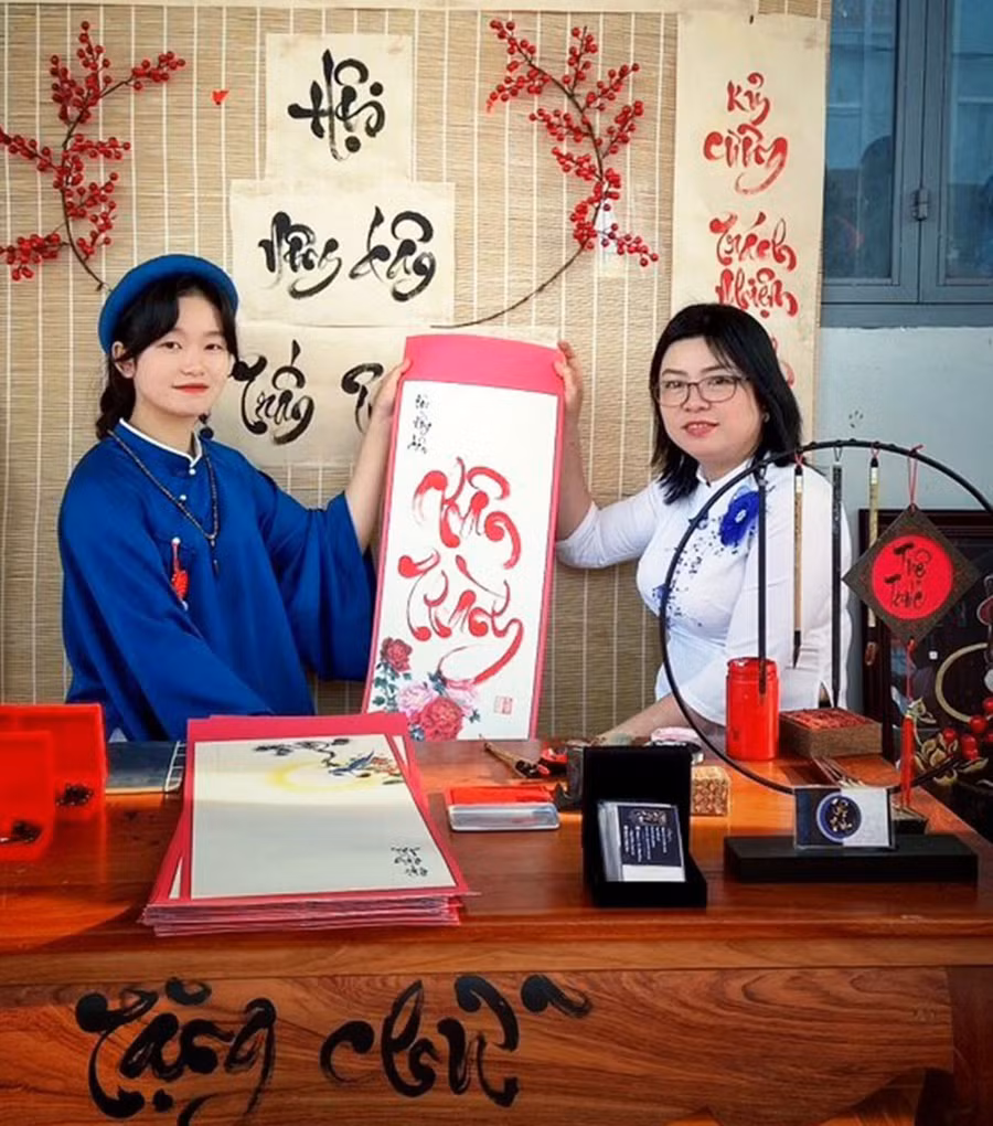 Chị Ngô Thị Kim Trúc (bìa trái)-Bí thư Chi Đoàn thôn 2 (thị trấn Phú Hòa, huyện Chư Păh) thường được mời tham gia các sự kiện viết tặng thư pháp. Ảnh: P.D