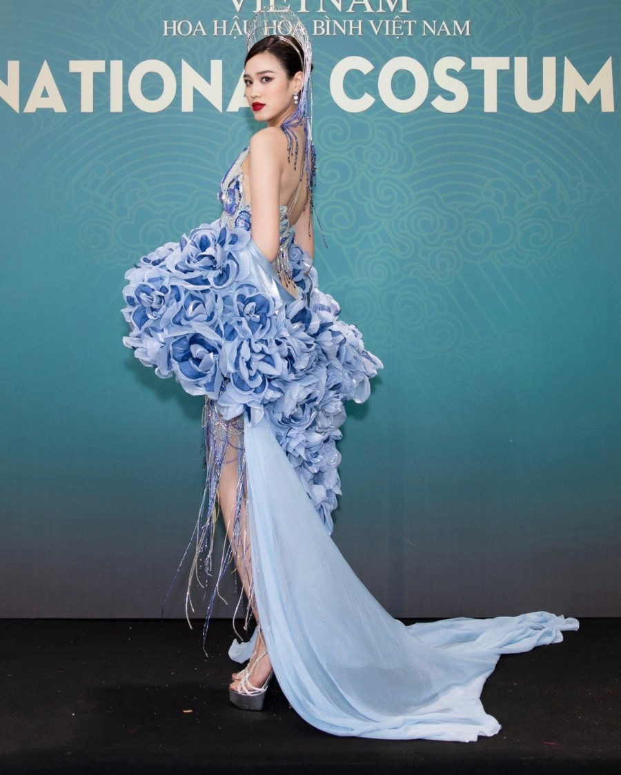 Hoa hậu Đỗ Thị Hà với trang phục in hoa cầu kỳ. Phần mấn tua rua kết hợp chân váy hiện đại tạo nên tổng thể ấn tượng.