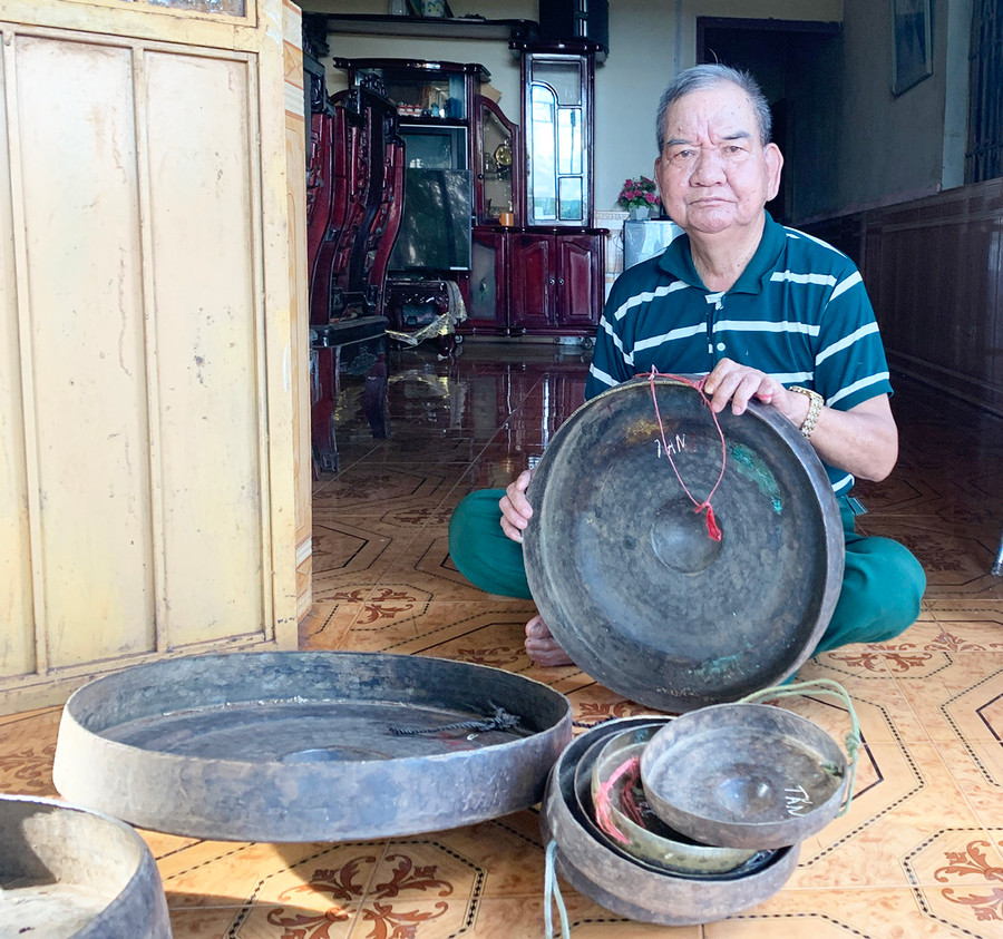 Ông Siu Tăn bên bộ cồng chiêng của mình. Ảnh: R.H