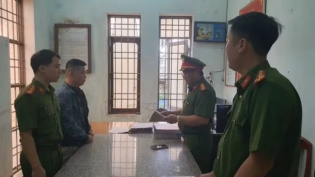 Công an đọc quyết định khởi tố và thực hiện lệnh bắt tạm giam đối với Hồ Xuân An. Ảnh: TRỊ BÌNH