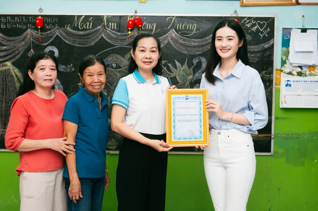 Hoa hậu Ý Nhi trao quà cho mái ấm Hướng Dương. Ảnh NVCC