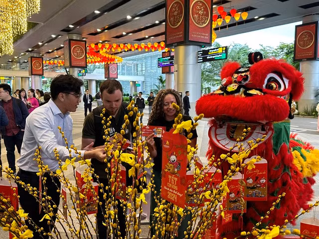 Nữ du khách Anna Mavrycheva, quốc tịch Nga, cùng bạn hái lộc trúng voucher may mắn. Ảnh: NGUYỄN TÚ