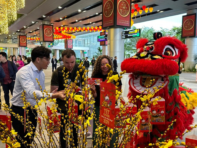 Nữ du khách Anna Mavrycheva, quốc tịch Nga, cùng bạn hái lộc trúng voucher may mắn. Ảnh: NGUYỄN TÚ