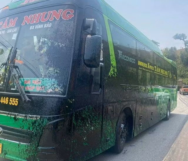 1 xe khách bị bắn nhựa đường lên thành xe. Ảnh: TRANG ANH