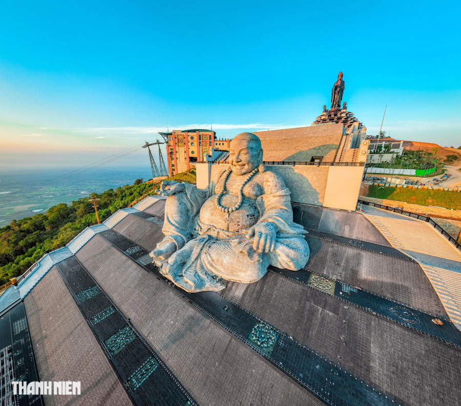 Phía sau lưng và bao quanh tượng Di Lặc Bồ Tát là thác nước nhân tạo khổng lồ với chiều cao 35m, tạo nên một khung cảnh kỳ vĩ trên đỉnh núi Bà Đen. Phía xa là tượng Phật Bà Tây Bổ Đà Sơn. Ảnh: BÙI VĂN HẢI