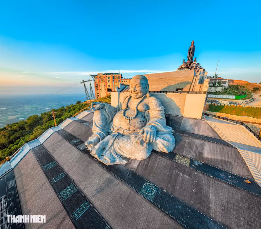 Phía sau lưng và bao quanh tượng Di Lặc Bồ Tát là thác nước nhân tạo khổng lồ với chiều cao 35m, tạo nên một khung cảnh kỳ vĩ trên đỉnh núi Bà Đen. Phía xa là tượng Phật Bà Tây Bổ Đà Sơn. Ảnh: BÙI VĂN HẢI