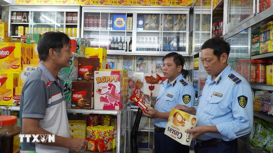 Cán bộ Quản lý thị trường Kiên Giang kiểm tra hàng hóa tại cửa hàng bách hóa tổng hợp ở phường Vĩnh Thanh Vân, TP Rạch Giá. (Ảnh: Văn Sĩ/TTXVN)